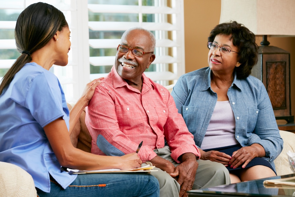 Nurse Making Notes During Visit With Senior Couple